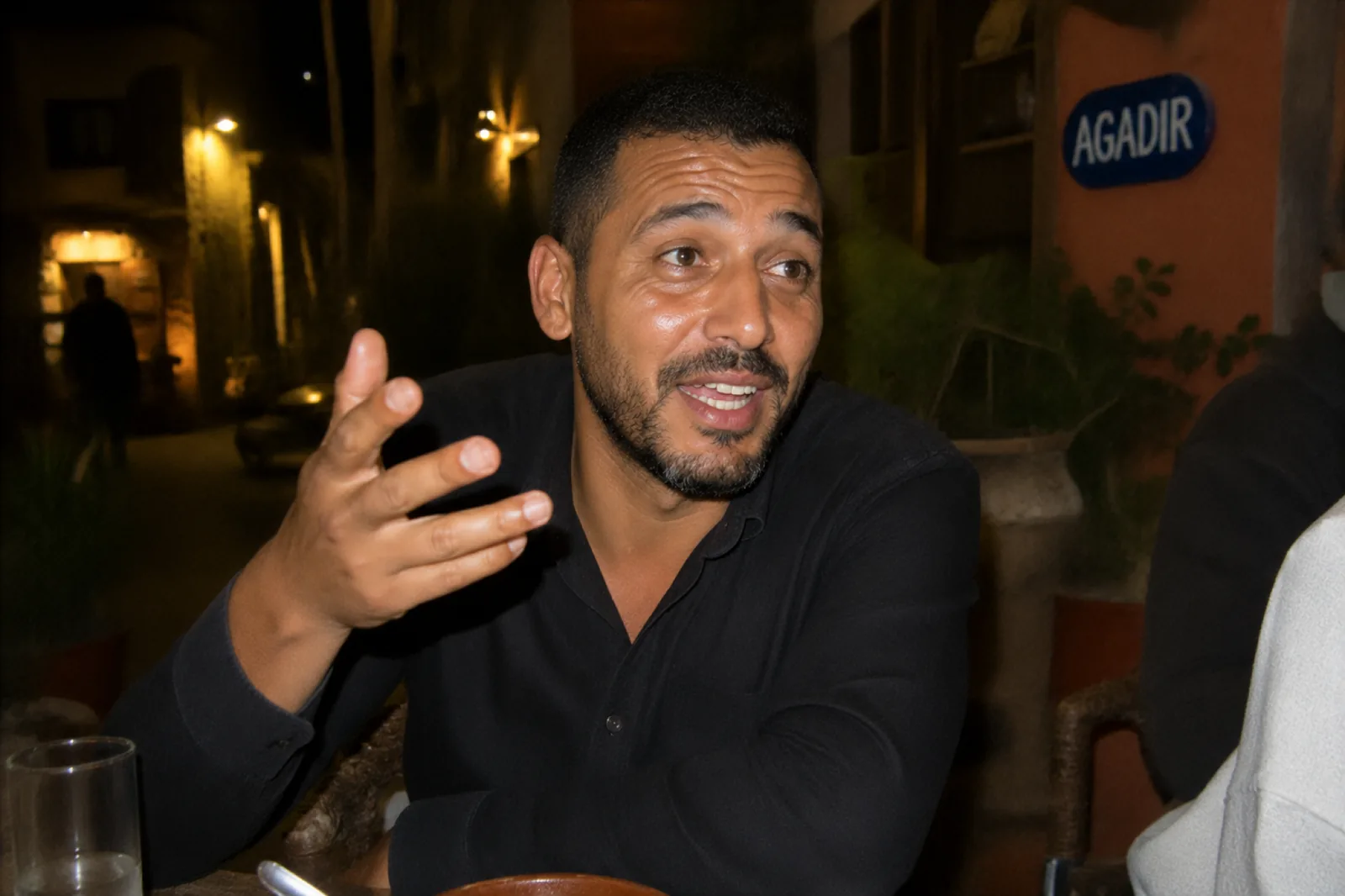 Youssef, chauffeur SDM, en discussion à une terrasse devant le panneau Agadir