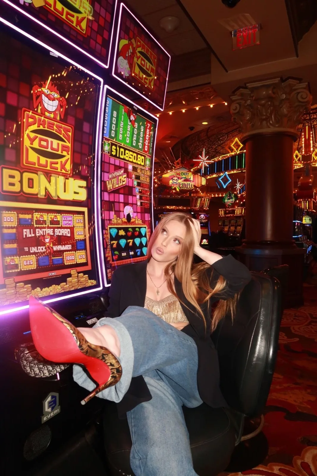 Young woman sitting back in a casino chair under the pink neon of the slot machines, shot on film